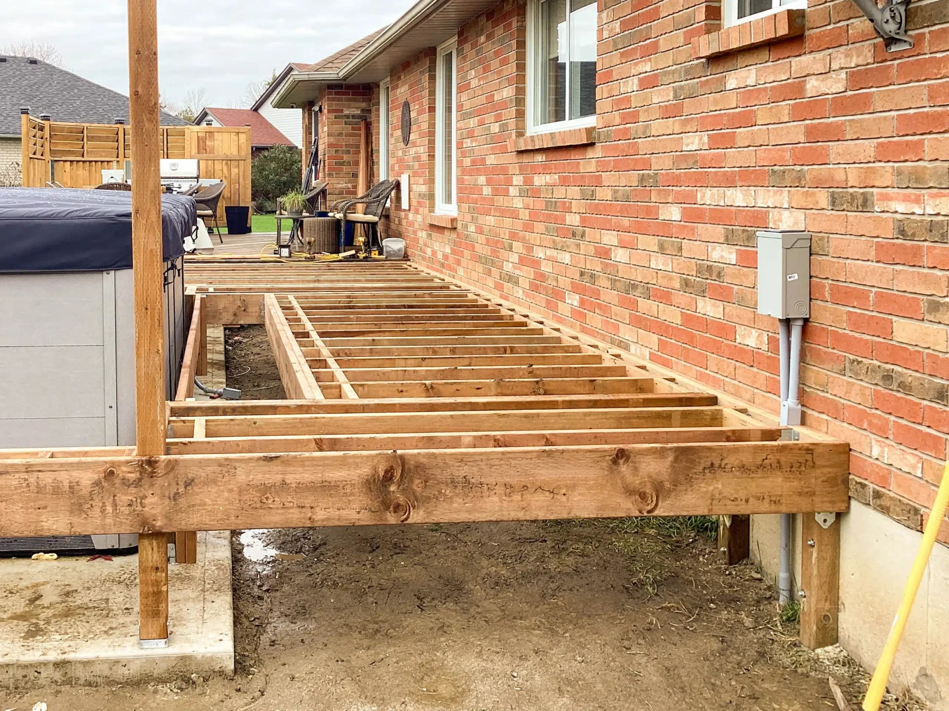 Deck framing along the side of a brick home