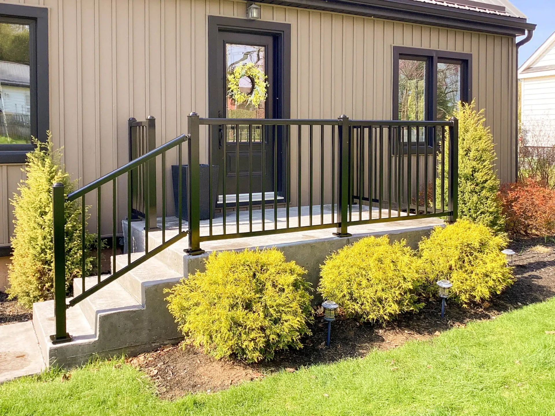 Concrete porch and steps with black aluminum railing